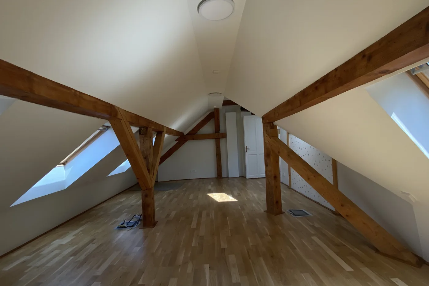 An empty room in apartment 9, sunlight from the roof windows on the oak floor